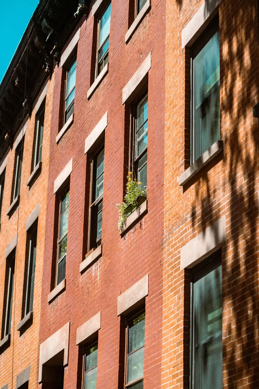 Klinkerfassade eines Mehrfamilienhauses im schrägen Sonnenlicht