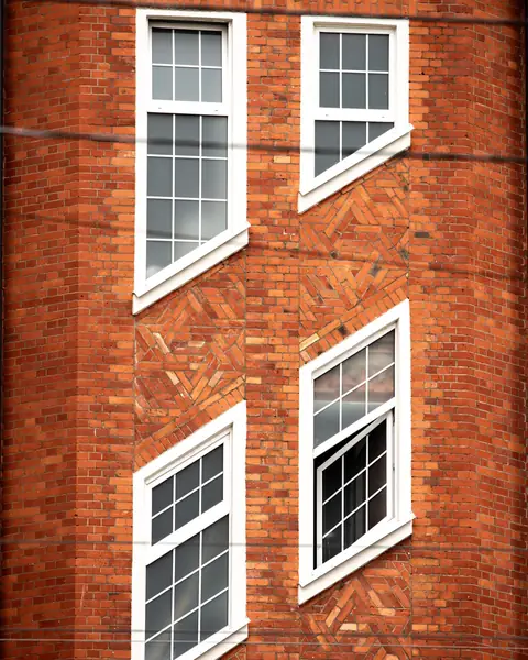 Klinkerfassade mit weißen Sprossenfenstern und Zierverband
